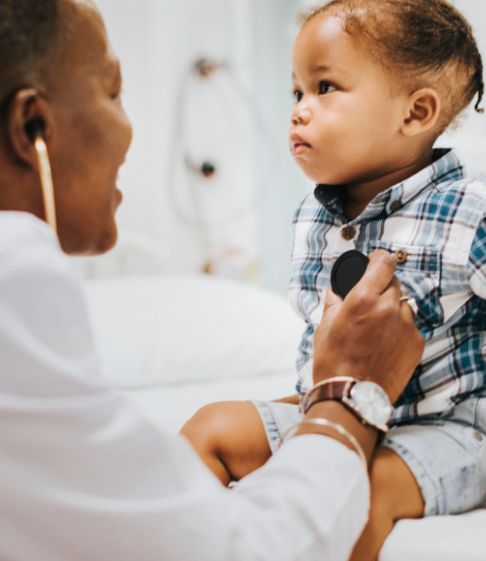 doctor using a stethoscope on a toddler