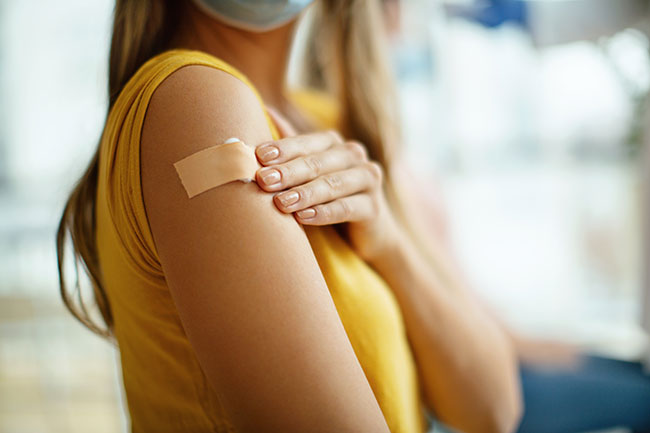 Girl with plaster on arm after receiving a vaccine injection