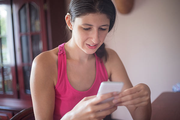 girl booking hospital visit with parent on her phone