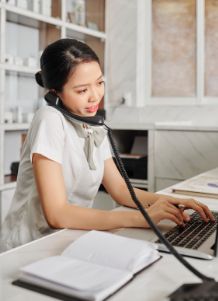 Office assistant on phone while typing